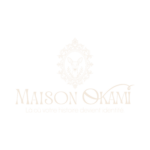 Logo Maison Okami couleur champagne avec emblème de biche et signature « Là où votre histoire devient identité ».