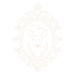 Logo Maison Okami couleur champagne avec tête de biche dans un cadre ornemental baroque.